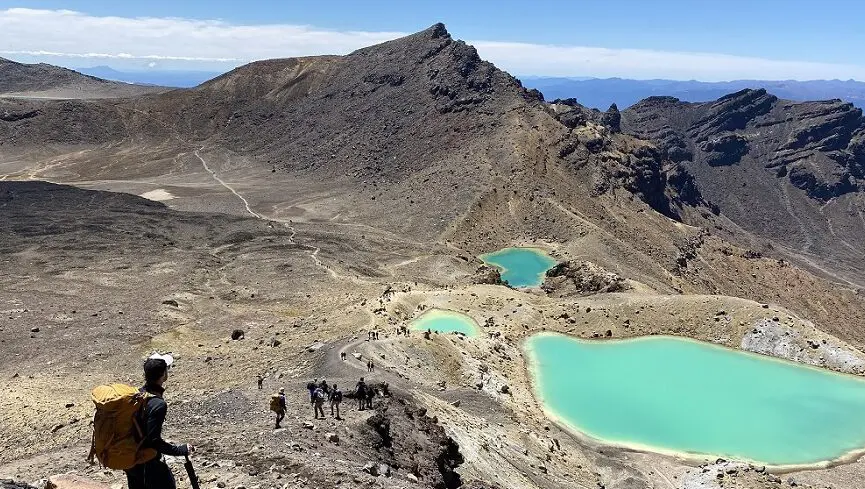 Hiker descends scree slope above Emerald Lakes