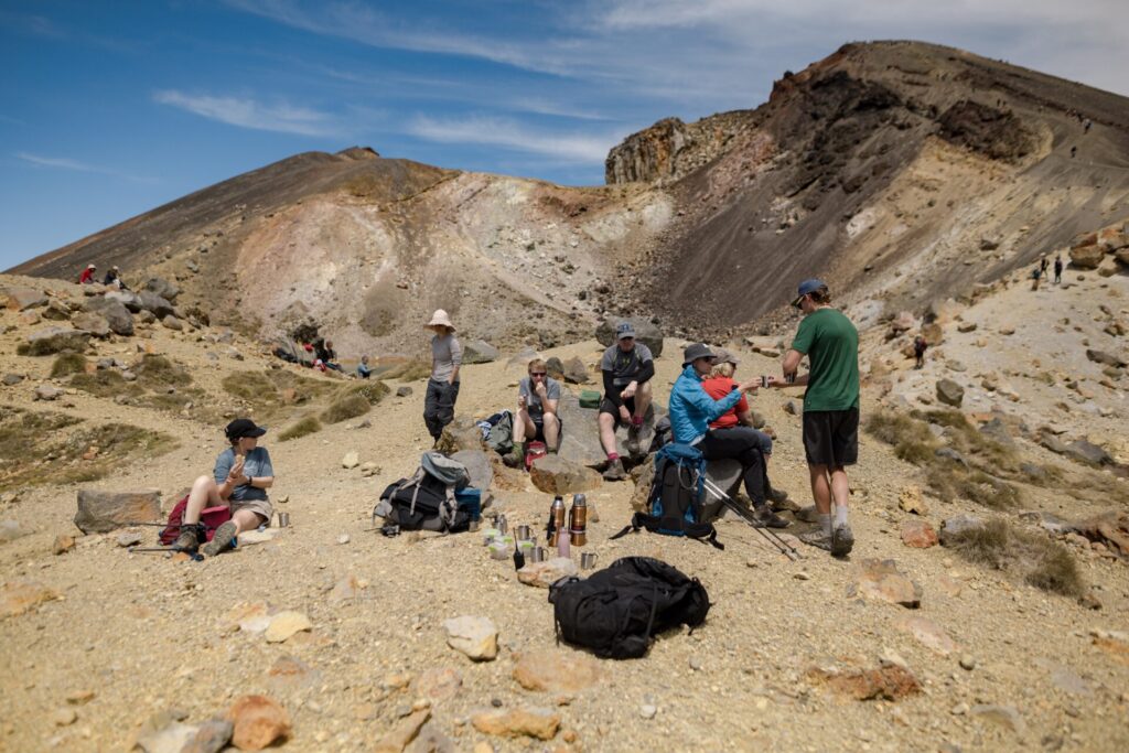 NZ hiking guides deliver hot tea and coffee to guests on the Tongariro Alpine Crossing hiking track