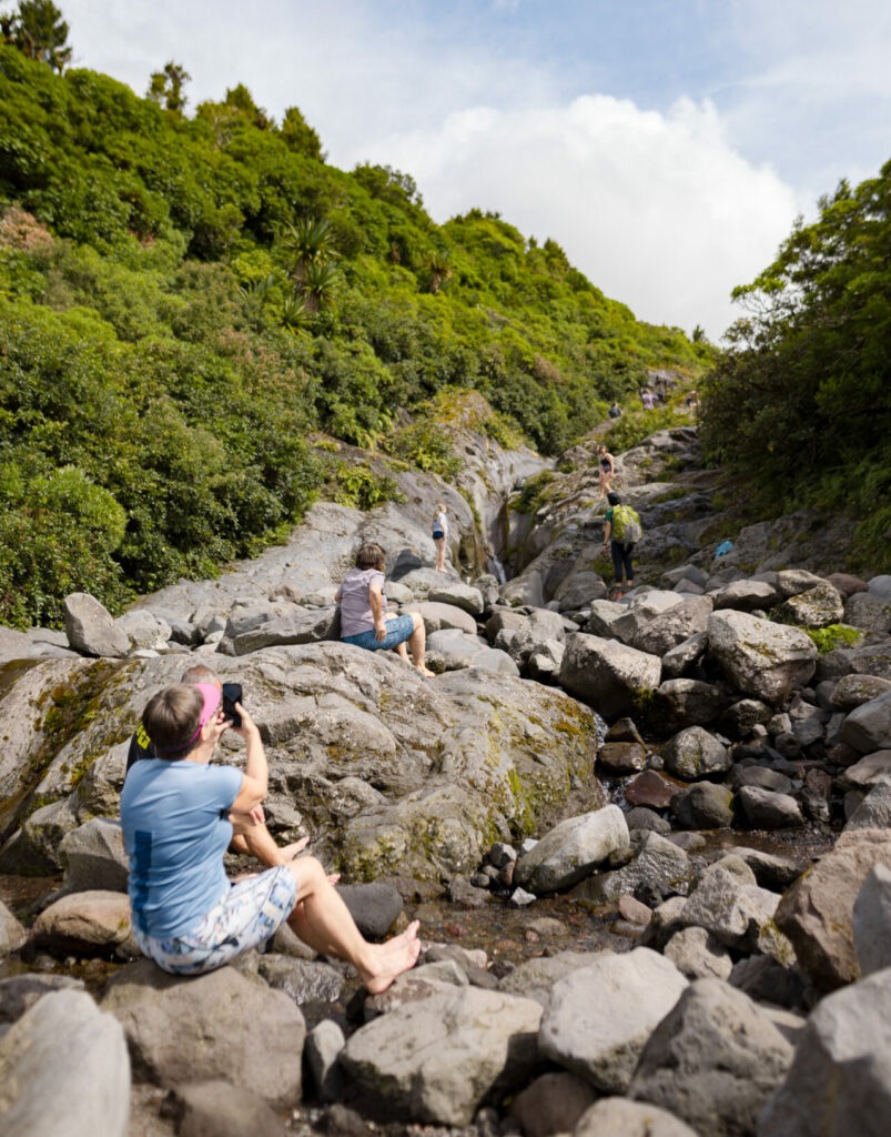 Hiker sits and captures photo of Wilkies Pool in Mt Egmont National Park, Taranaki