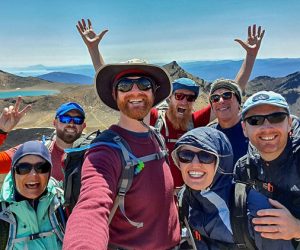 A group of hikers celebrate completing the Tongariro Alpine Crossing guided hike with Walking Legends